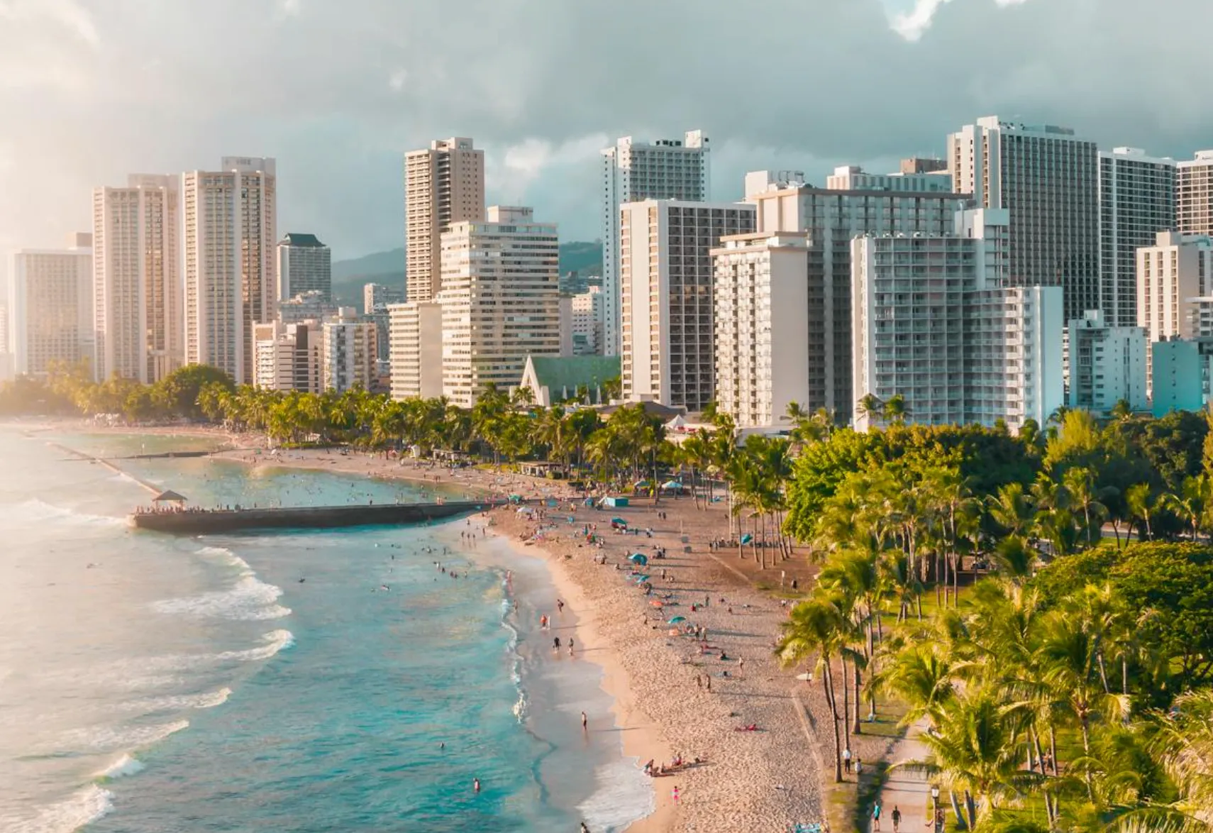 Image: Kids building sandcastles at Waikīkī Beach with Diamond Head in the background