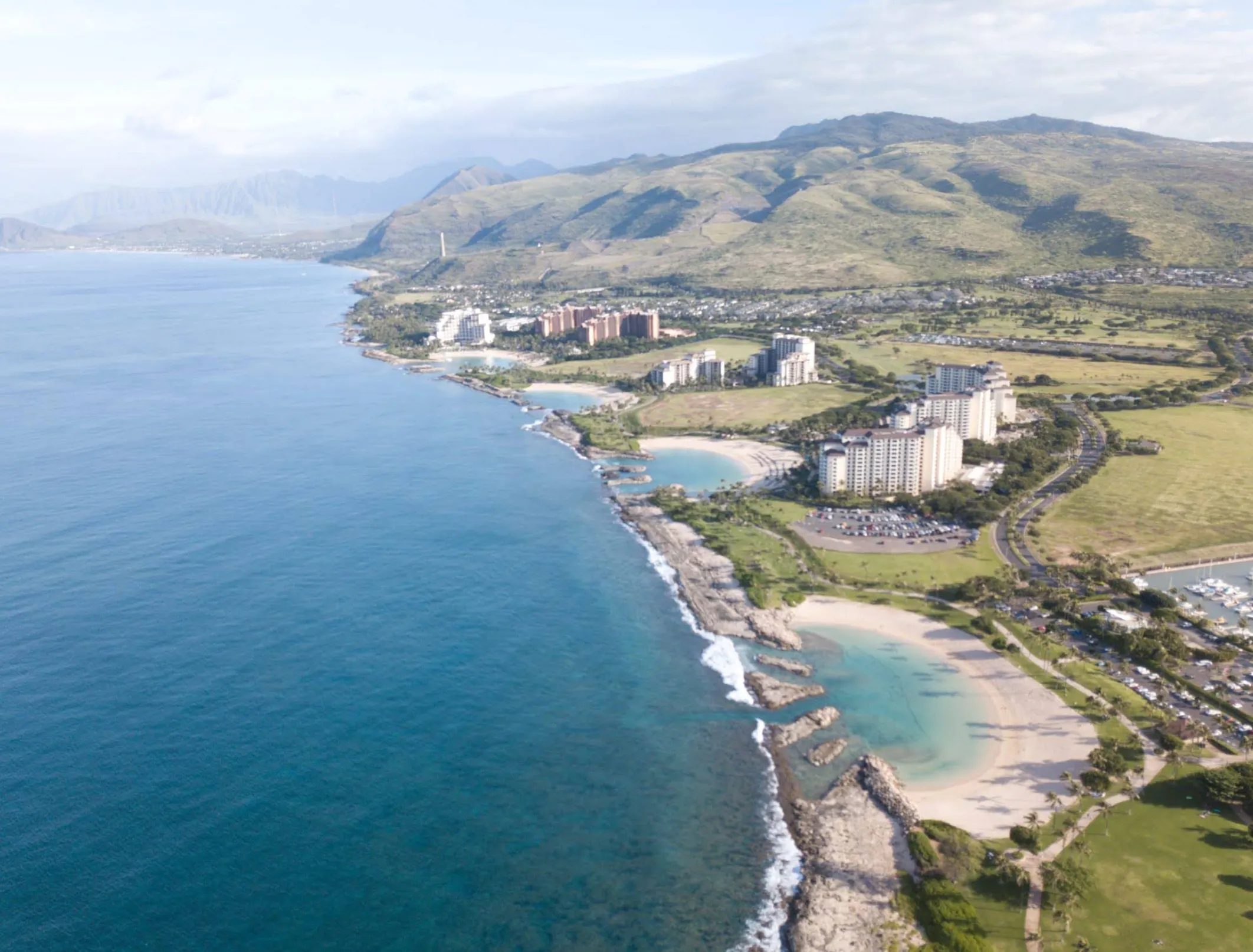 Image: Toddler splashing in a shallow man-made lagoon at Ko Olina with palms lining the shore